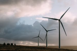 Wind turbines generating renewable energy under a dramatic cloudy sky.